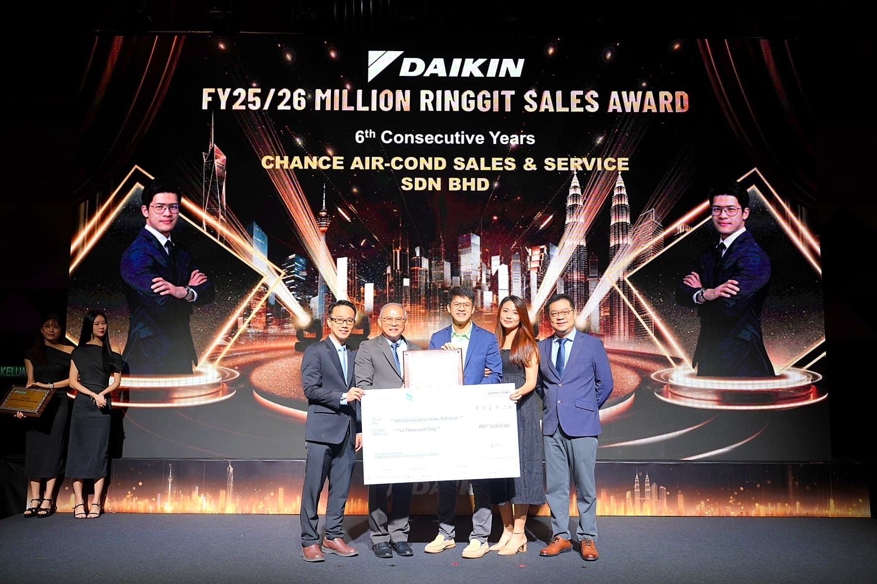 CASS 团队在大金颁奖典礼上领奖，身后大屏显示：FY25/26 Million Ringgit Sales Award，6th Consecutive Years，Chance Air-Cond Sales & Service Sdn Bhd。