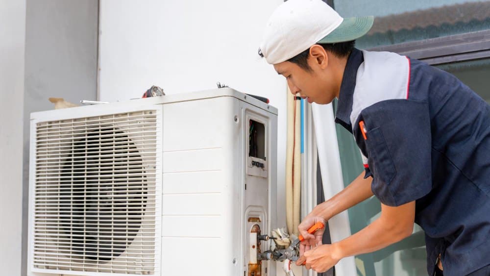 A technician diagnosing a fault on an air-conditioning unit.