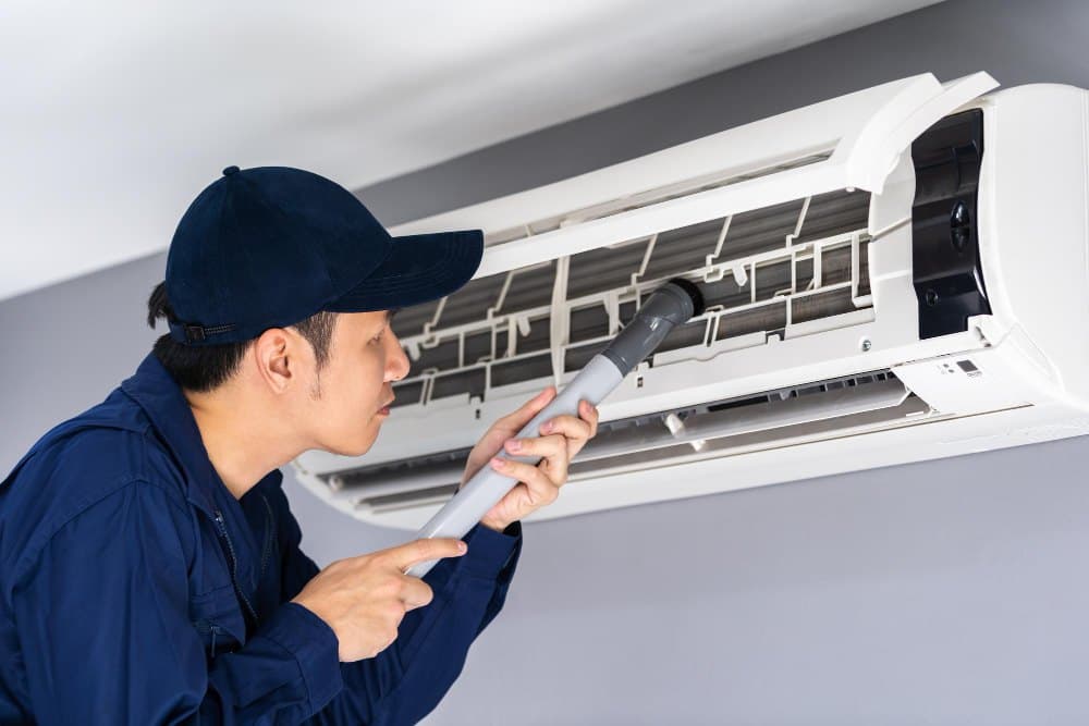 A technician servicing a home air-conditioning unit.