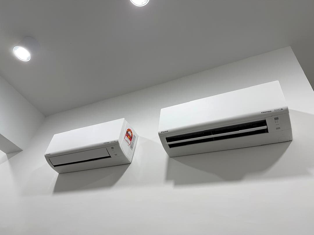 Two wall-mounted split units of different capacities on the same wall.