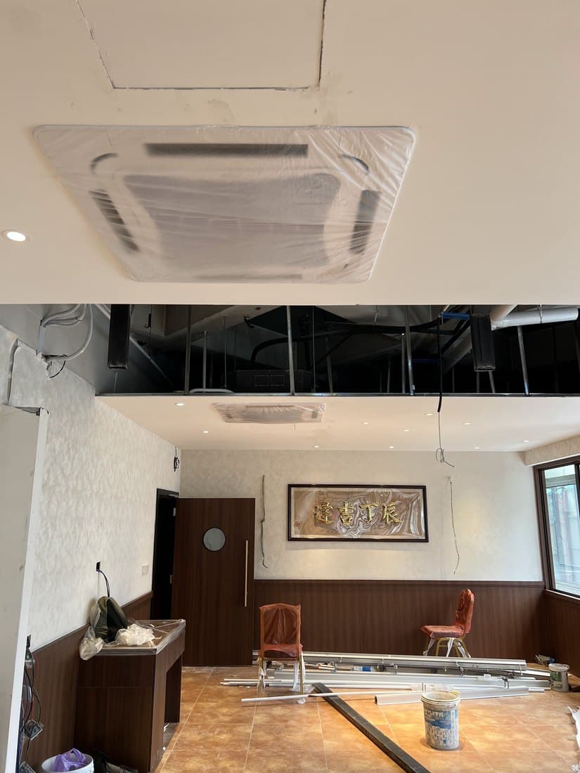 A ceiling cassette still in its protective wrapping, fitted above a dining room during fit-out.