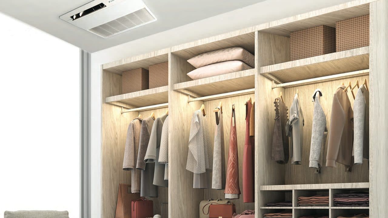 A walk-in closet with a ceiling cassette above the shelves.