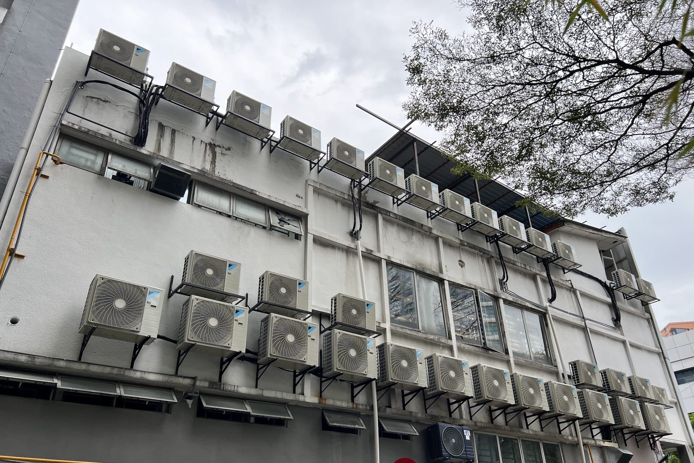 The rear wall of a restaurant building, carrying rows of outdoor air-conditioning units on brackets across several storeys.