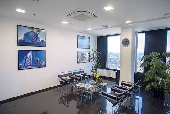 An office reception area with a ceiling cassette set flush into the plastered ceiling above the seating.