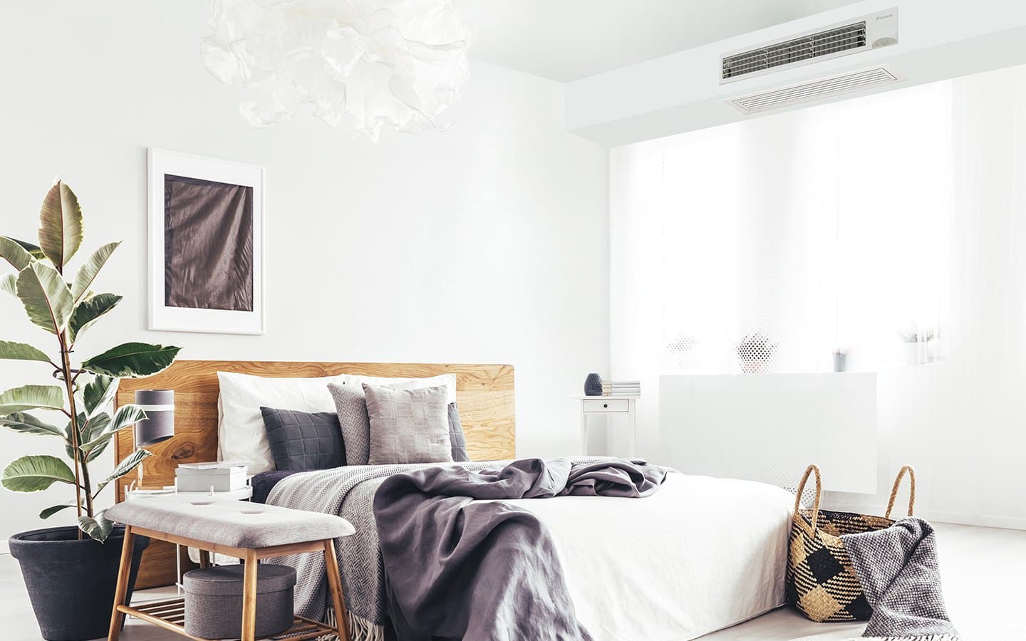 A bedroom supplied through a slim ceiling grille from a concealed ducted unit.