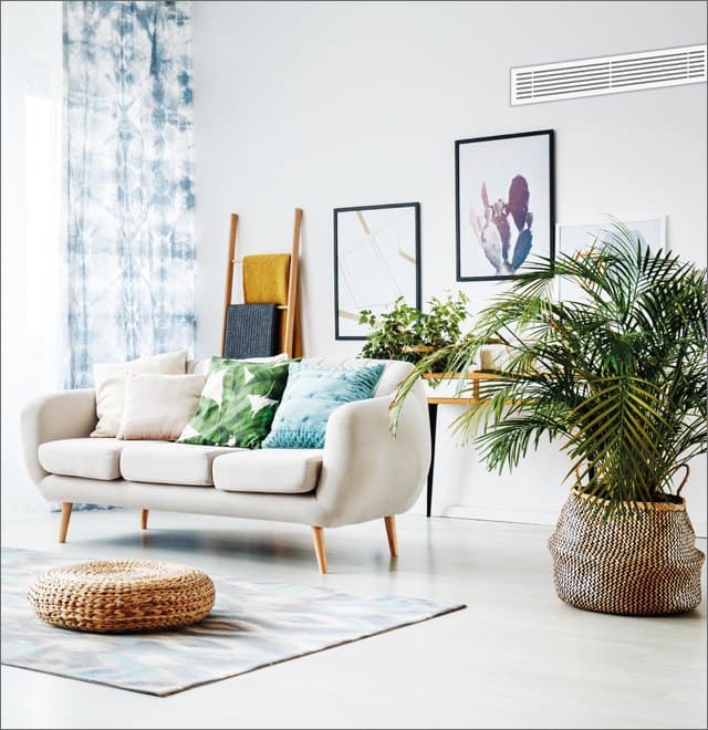 A living room with a linear supply grille set flush into the ceiling line.