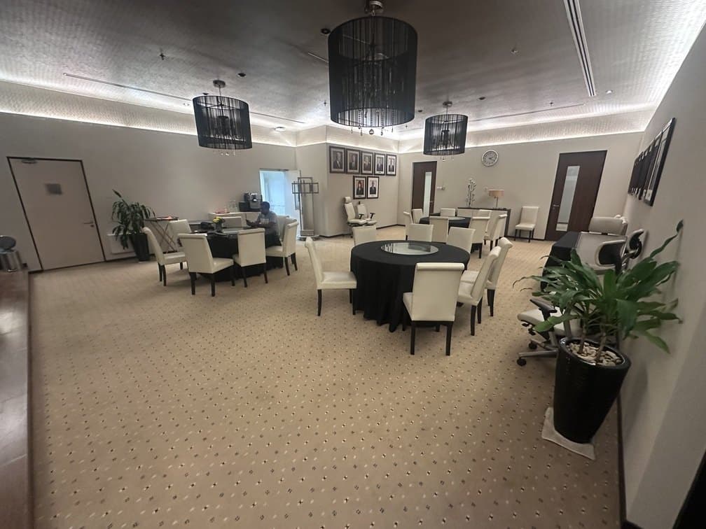 A staff dining and meeting area with round tables and ceiling-mounted units above.