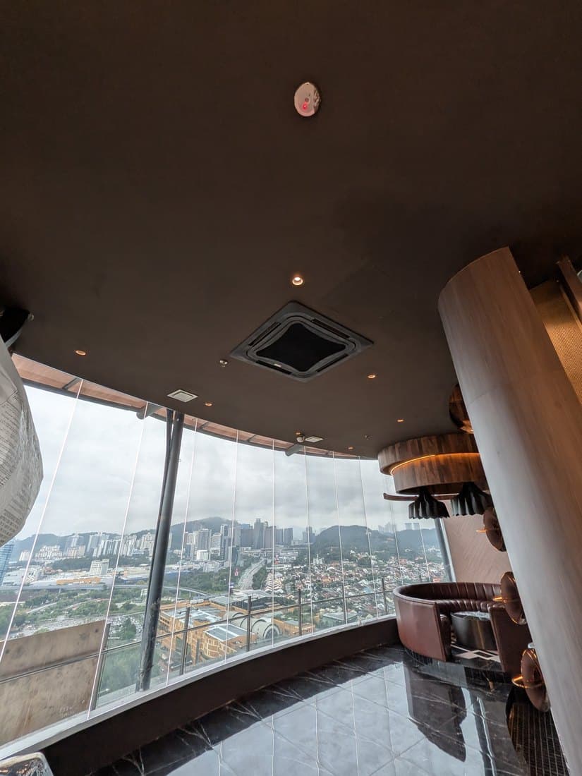 A ceiling cassette above a curved full-height window bay in the lounge.