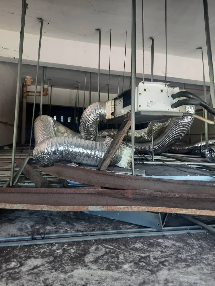 A concealed ducted fan-coil unit suspended in the ceiling void with insulated flexible ductwork branching from both sides.