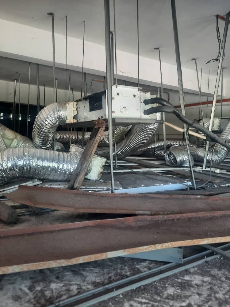 The same concealed ducted unit from a wider angle, showing the run of flexible ductwork across the ceiling void.