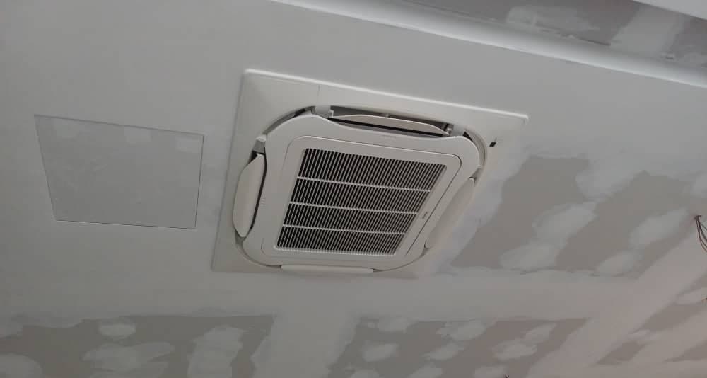 A ceiling cassette set into a plasterboard ceiling during fit-out, joints still unfinished.