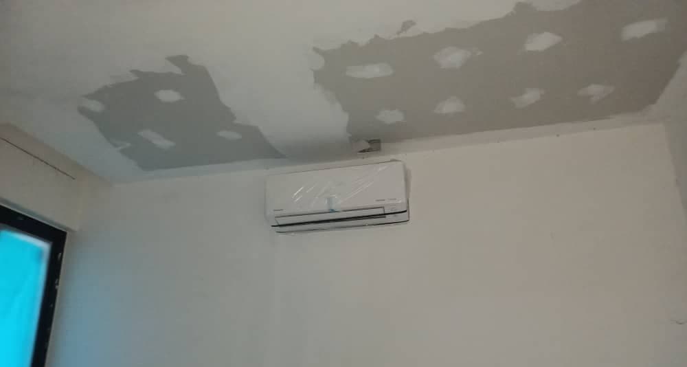 A wall-mounted indoor unit fitted high on a bedroom wall during the renovation phase.