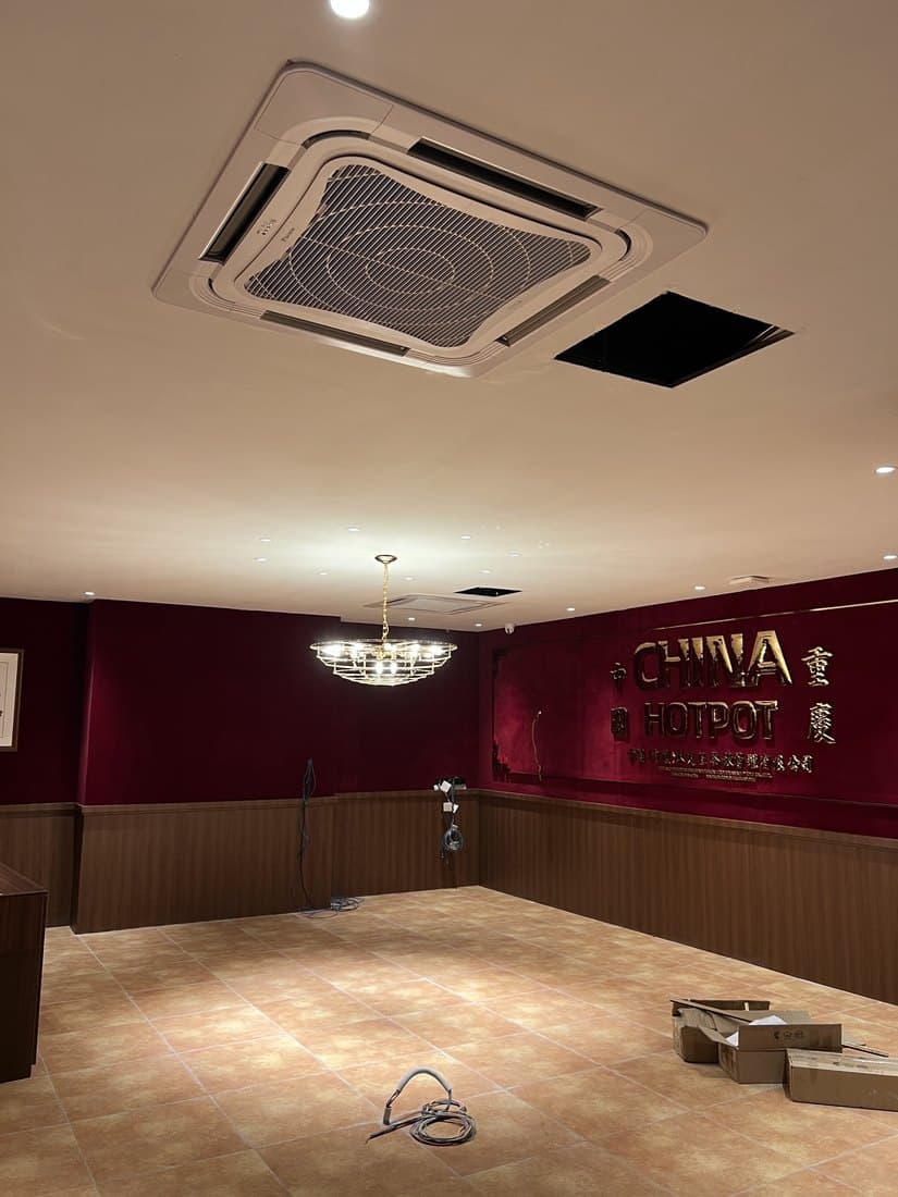 A finished dining room with a ceiling cassette set into the ceiling above the seating.