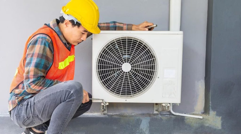 A technician assessing an old air conditioner for the needed repairs