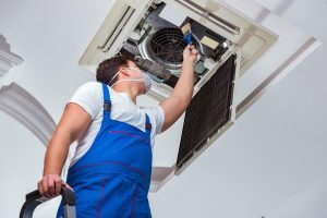 worker-repairing-ceiling-air-conditioning-unit